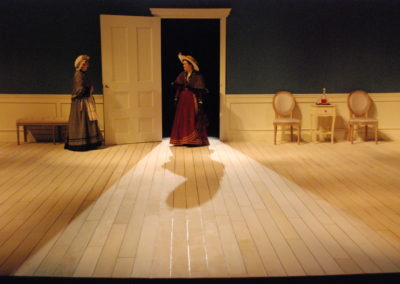 woman standing in open doorway, backlit, with another woman standing next to the opened door
