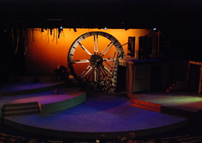 Colorful light across empty stage, focus on the mill wheel
