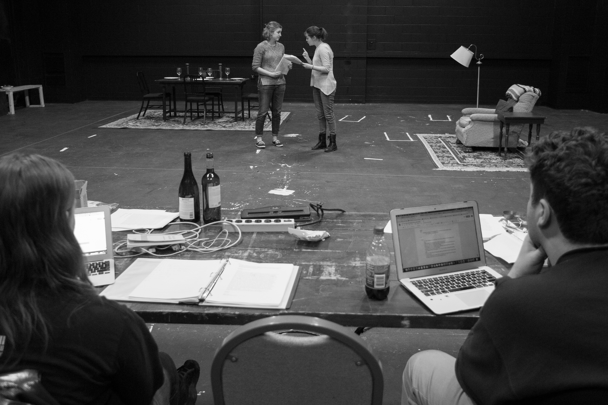 two stage managers watch as two performers rehearse