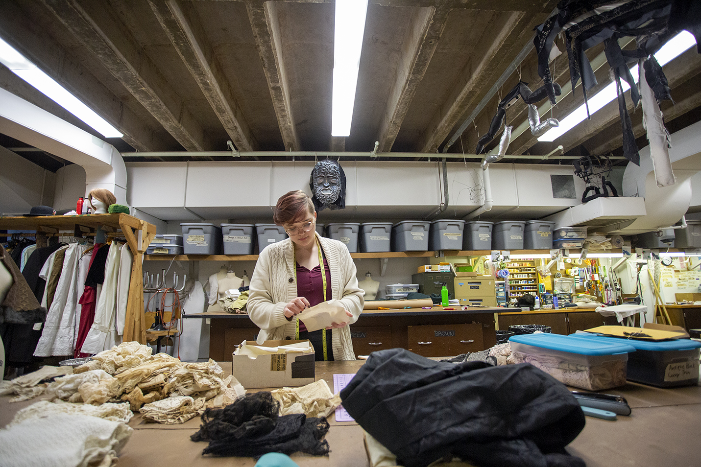 A student technician in the costume shop organizes lace