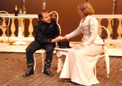 a man and a woman sit talking and holding hands