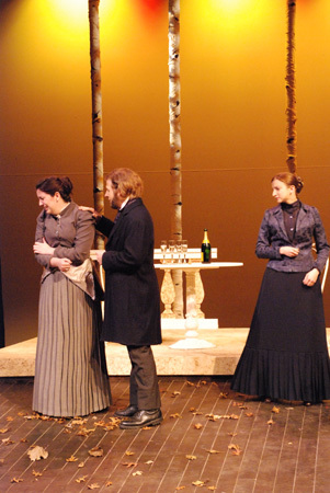 a man stands and consoles a woman, another woman look on
