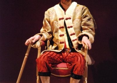 the king sitting in his throne, holding his walking cane