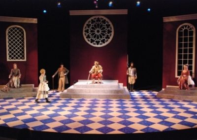 full stage, three scenic units, six people spread evenly across the stage in various poses