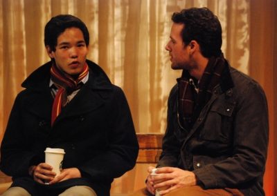 two men sitting and talking, drinking coffee