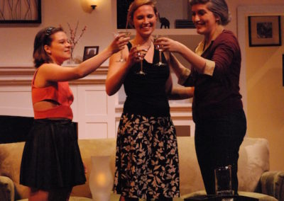 three women standing and toasting with martini glasses