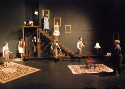 full stage with nine people about, some on a platform, some on stairs, some on the floor
