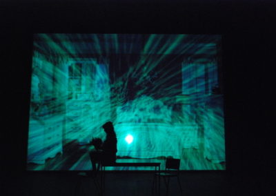 silhouette of woman sitting in the edge of a table, projected image of glitched girls bedroom on backdrop