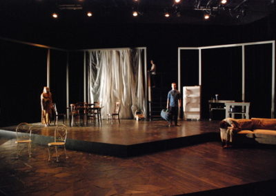 end of play, stark scene with two people standing in harsh white light