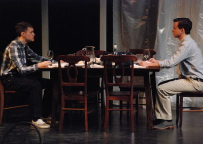 two men sitting at a dining room table, talking