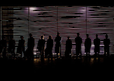 backlit performers standing in a row